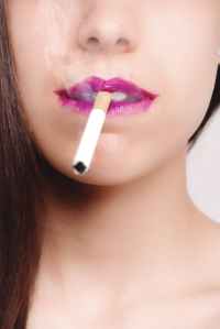 brown haired woman with pink lipstick biting white cigarette stick