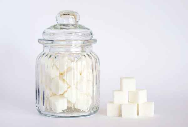 close up photo of sugar cubes in glass jar